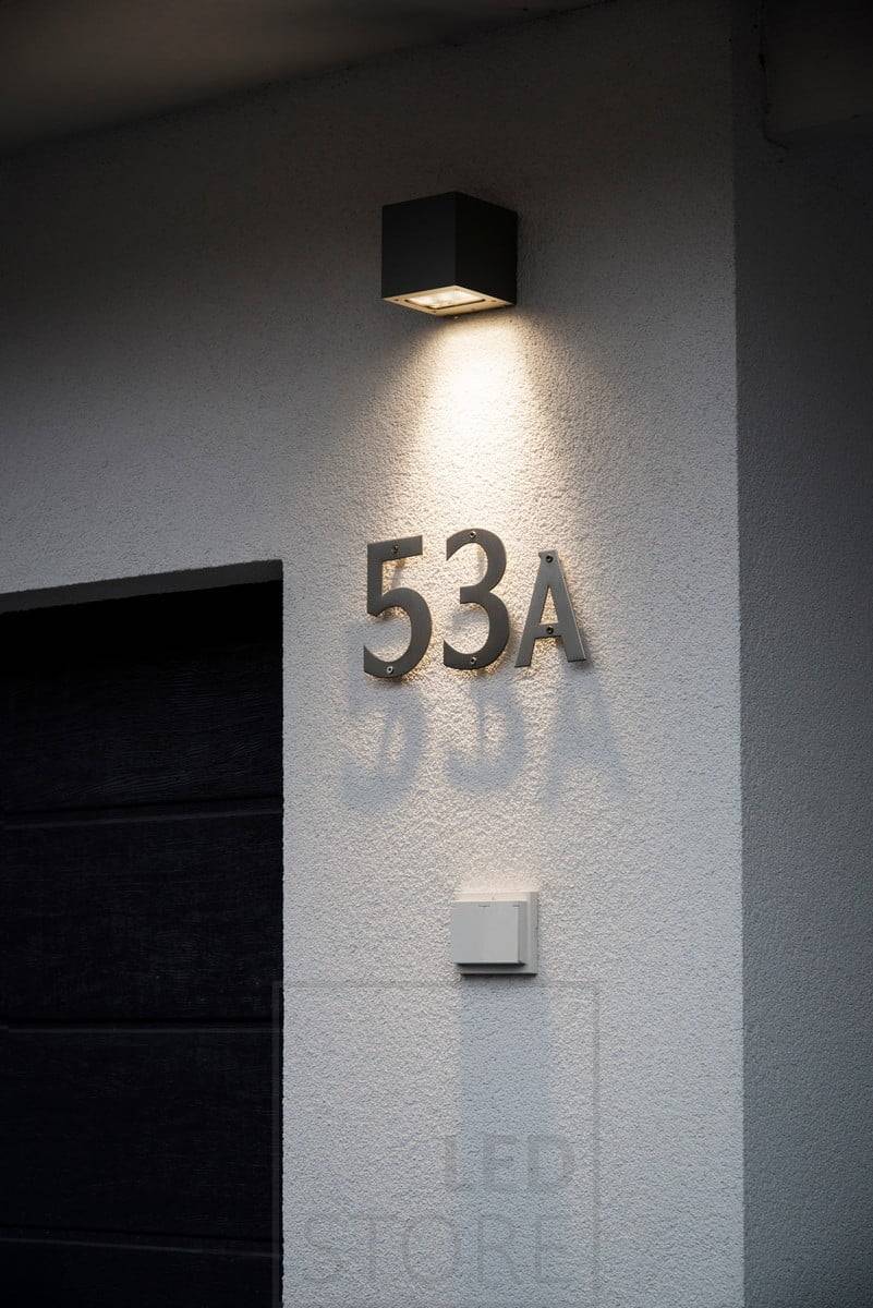 Aplique led CUBIC OUT que ilumina en una dirección por encima del número de la casa. La luz es suave y cálida a 3000 kelvin. Ledstore.fi